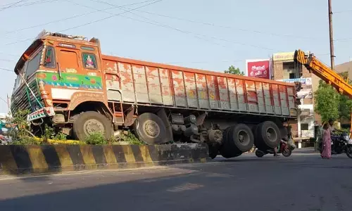 అదుపుతప్పి డివైడర్ ఎక్కిన లారీ