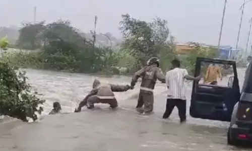 వరదలో కొట్టుకుపోతున్న వ్యక్తిని కాపాడిన ఇద్దరు కానిస్టేబుళ్లు