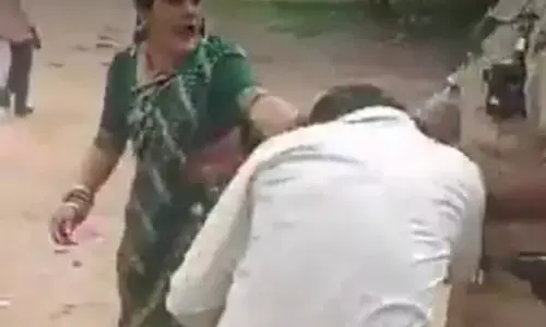 పోలీసుల ముందే.. భర్తను చితగ్గొట్టిన భార్య.. (వీడియో)