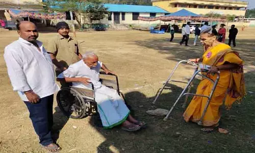 భ‌ర్త‌ను భుజాన వేసి ఓటు వేయించిన స‌తి..!
