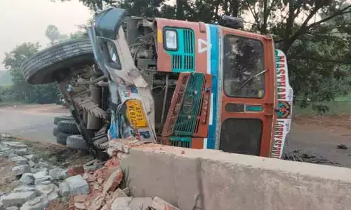 డివైడర్‌ను ఢీకొట్టి లారీ బోల్తా