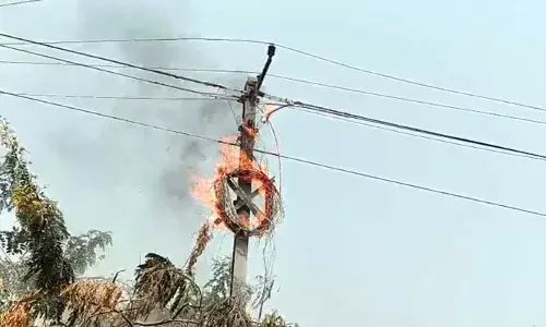 మున్సిపల్ అధికారుల నిర్లక్ష్యం.. విద్యుత్ స్తంభానికి అంటుకున్న మంటలు