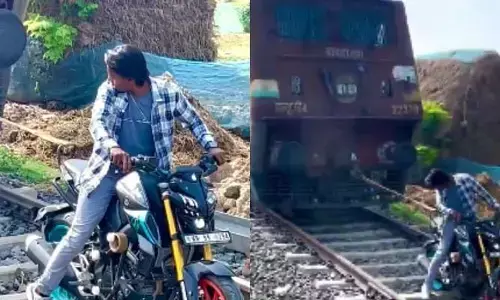 పిచ్చి పీక్స్‌: బైక్‌తో రైలును లాగే ప్రయత్నం.. నెటిజన్ల ఫైర్